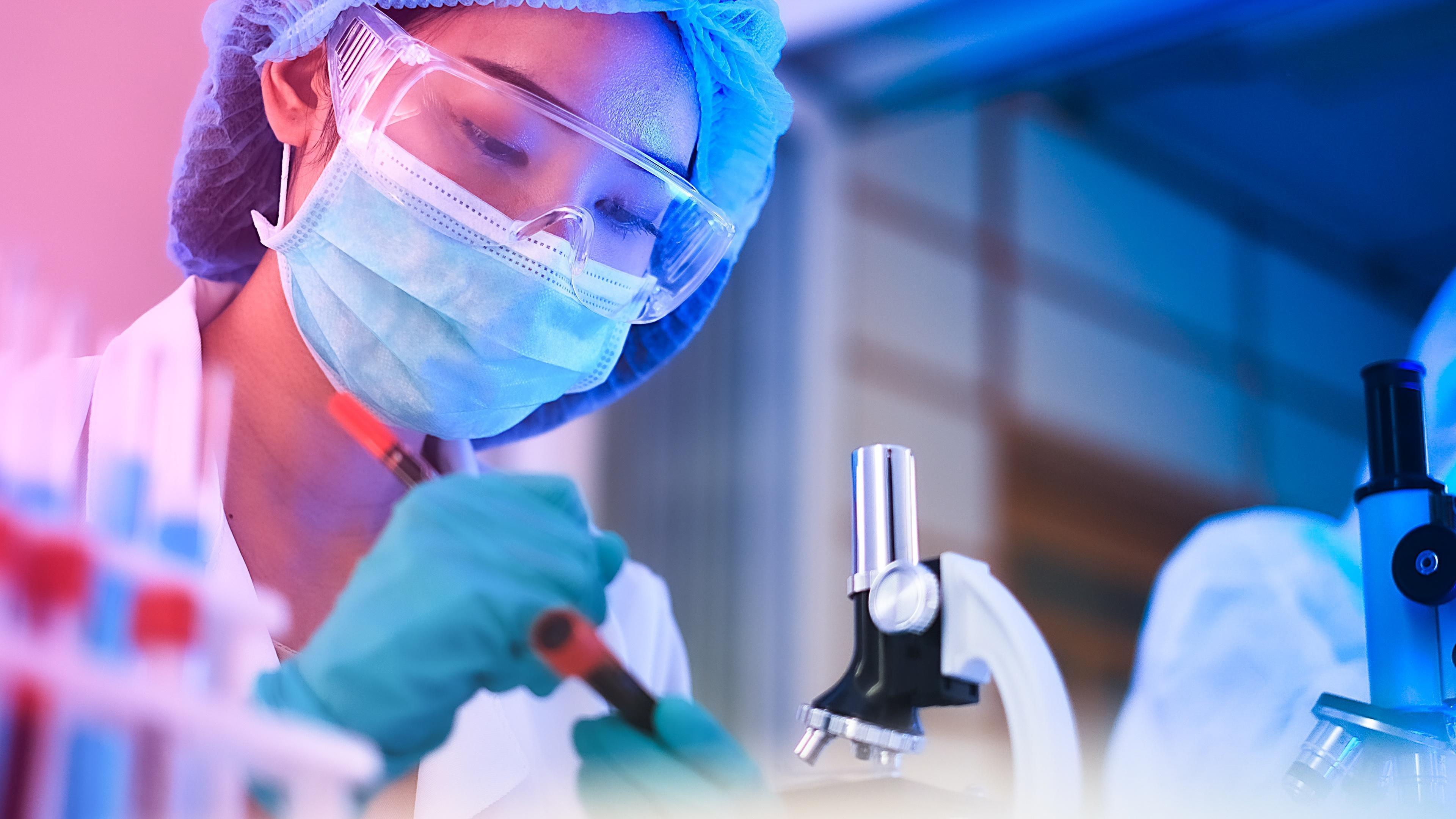 a worker with microscope is testing raw materials