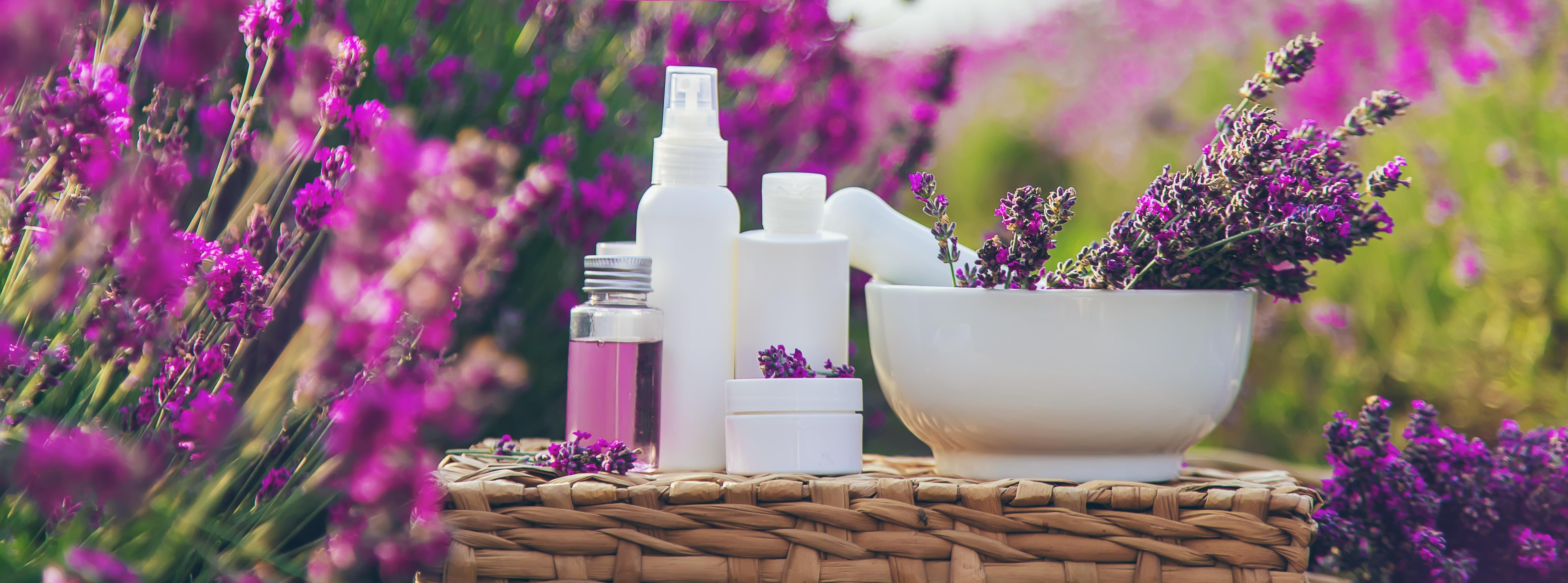bottles with cosmetic in front of lavender